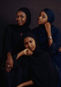 three women in black clothing pose for a photo