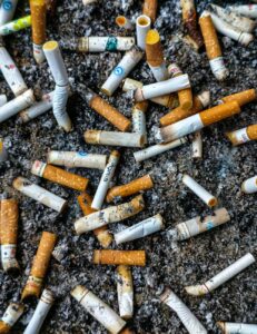 close up of multiple cigarette butts in ashtray